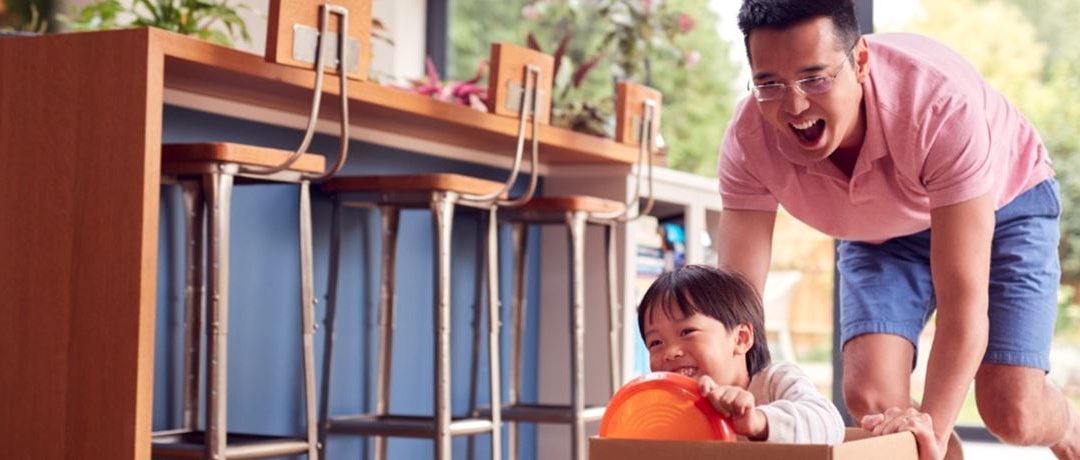 Asian Father and Son Pushing Son Around the kitcheen floor at home - Go Mortgage